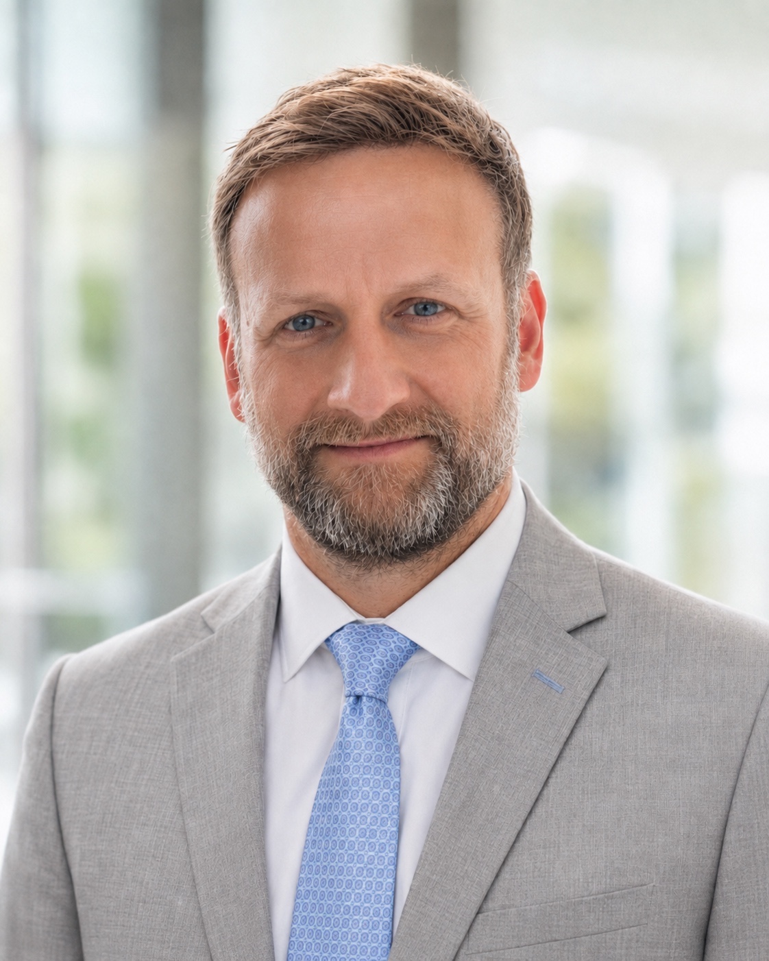 Elliot Servais, MD, in a gray suit and blue tie